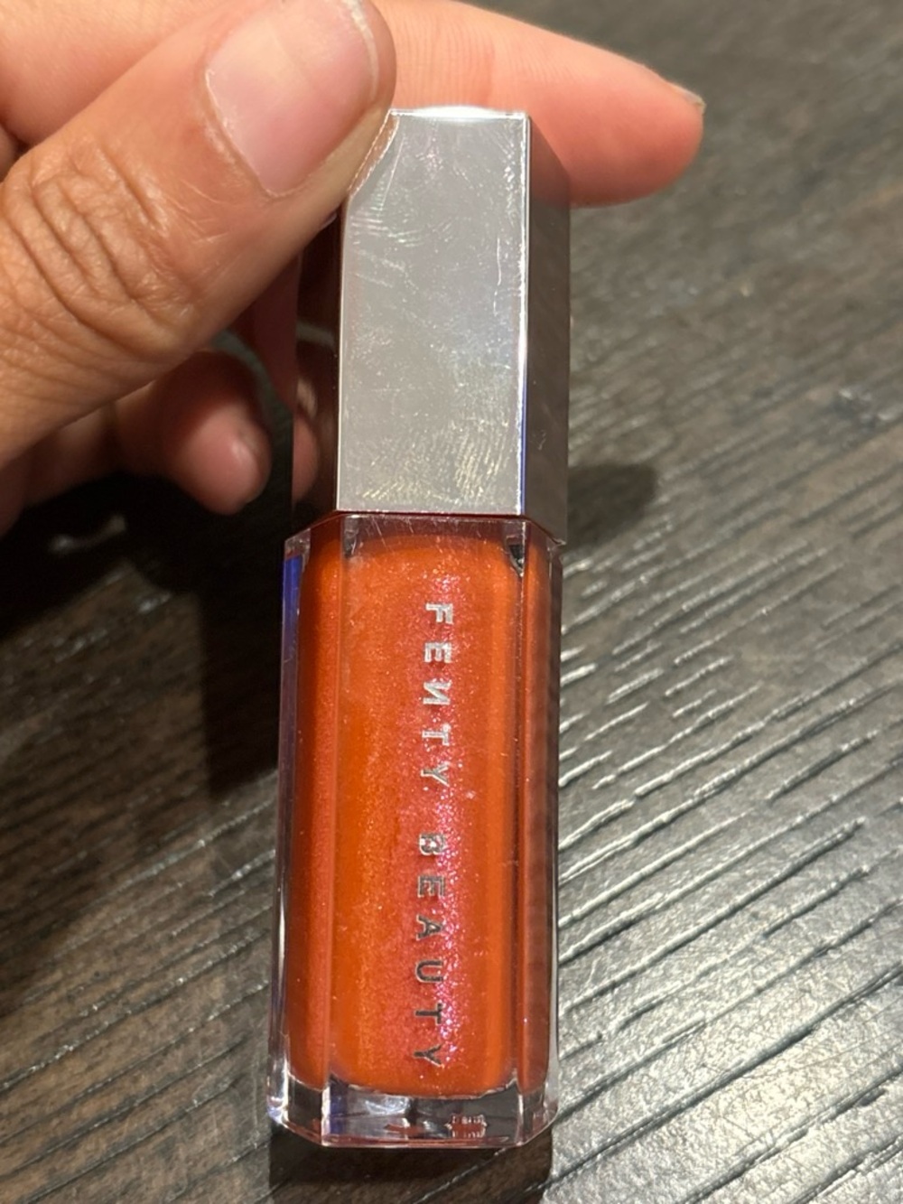 Fenty Beauty Shimmery Orange Lip Gloss with Silver Cap